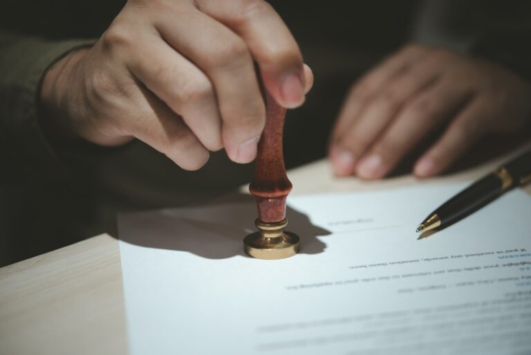 Businessman hands stamping rubber on important paperwork.